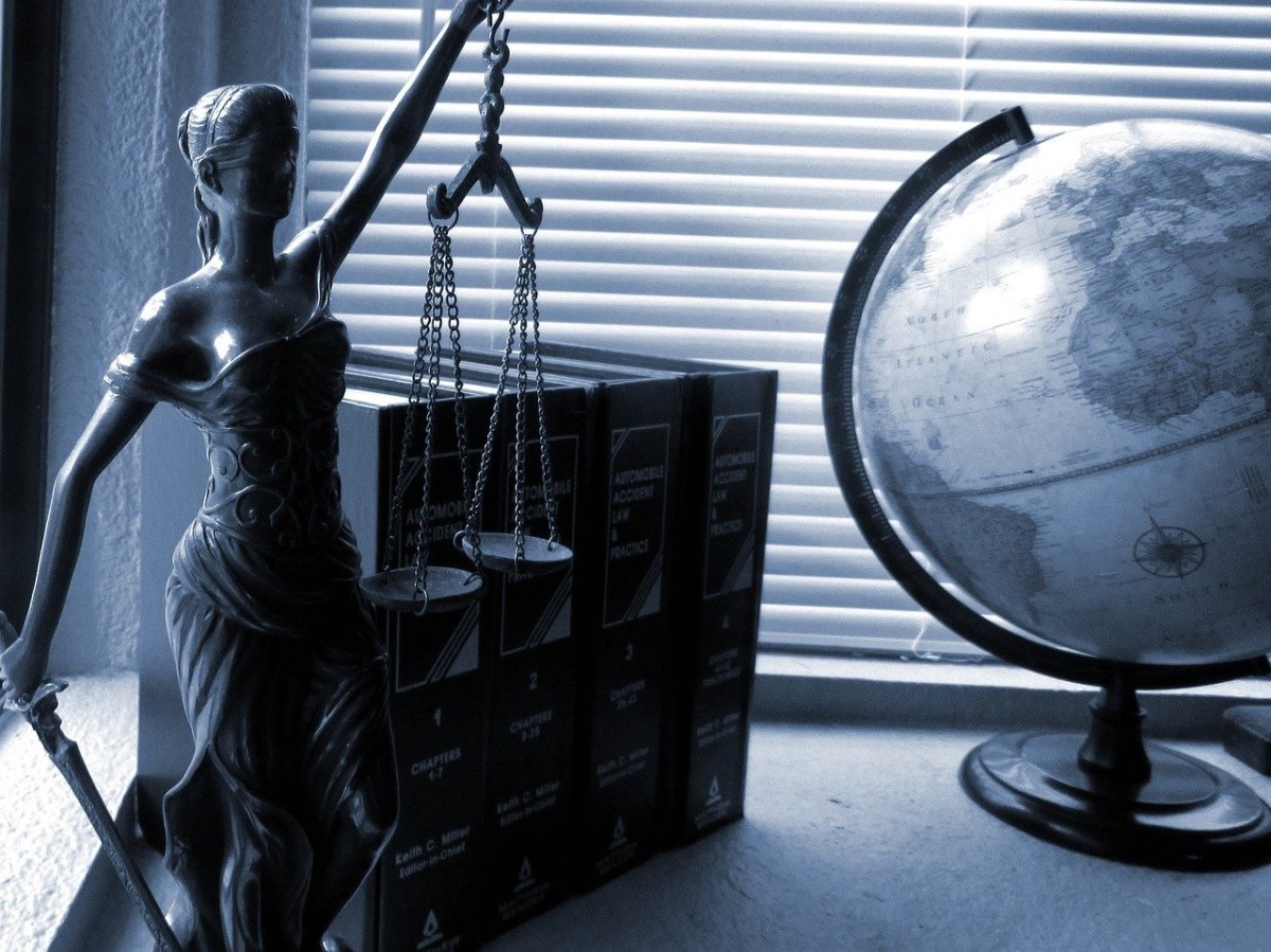 Symbole sprawiedliwości - kobieta, globus, kodeksy