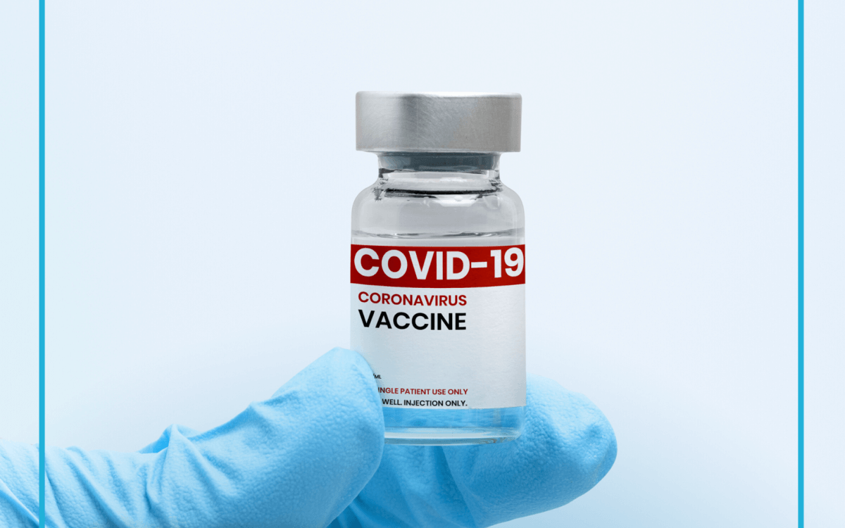 Szczepionka na COViD trzymana w dłoni ubranej w rękawiczkę chirurgiczną