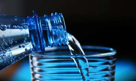 Woda nalewana z butelki do szklanki