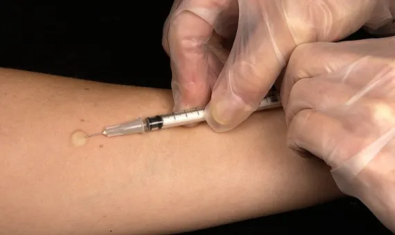 Szczepienie przeciwko grypie strzykawką w rękę