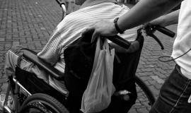 Osoba na wózku inwalidzkim prowadzonym przez inną osobę